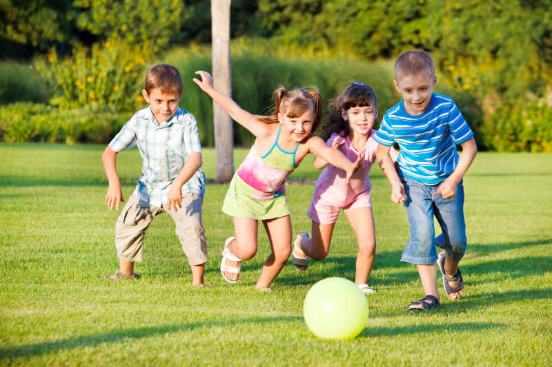 草地上的儿童在玩足球