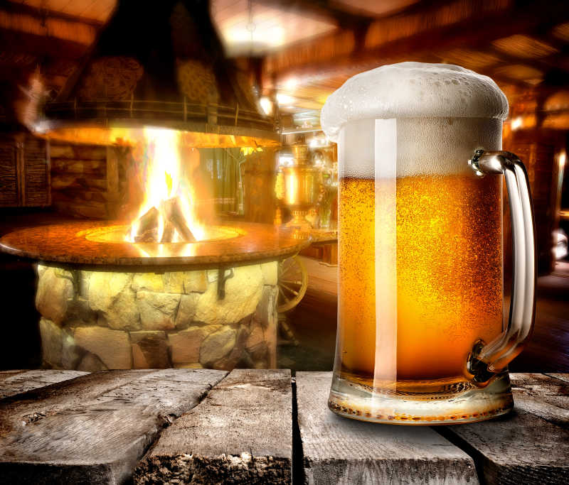 火炉旁的木板上放着一杯啤酒