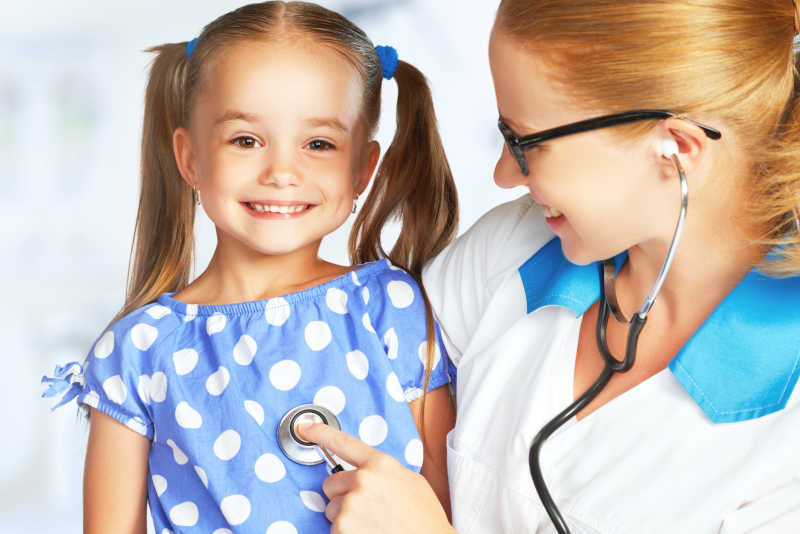 医生用听诊器为小女孩做胸部检查