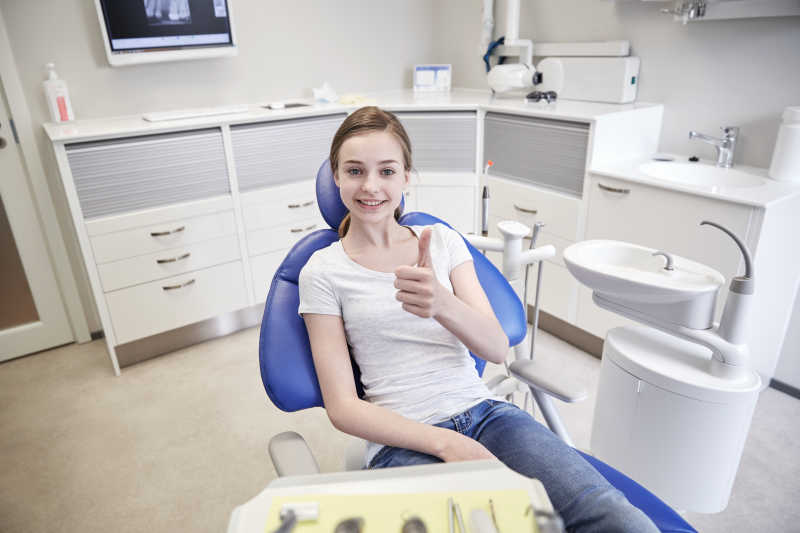 快乐的女孩在牙科诊所里