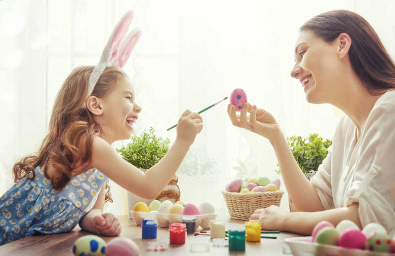 女孩和母亲在画复活节彩蛋