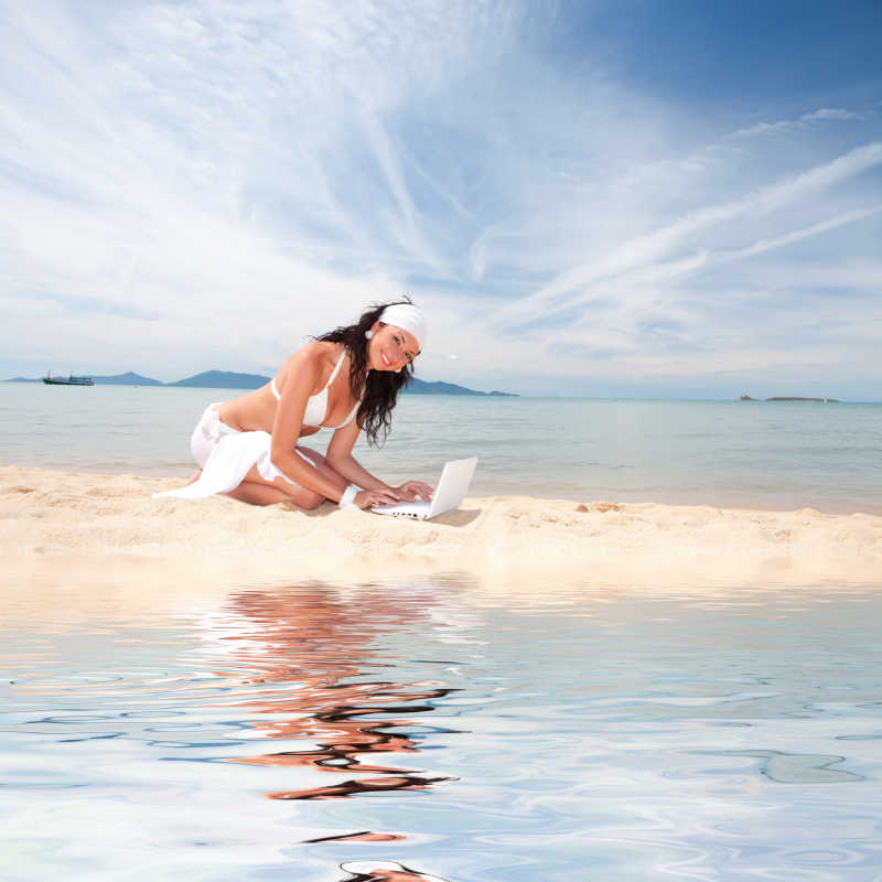 海滩上打电脑的性感女人