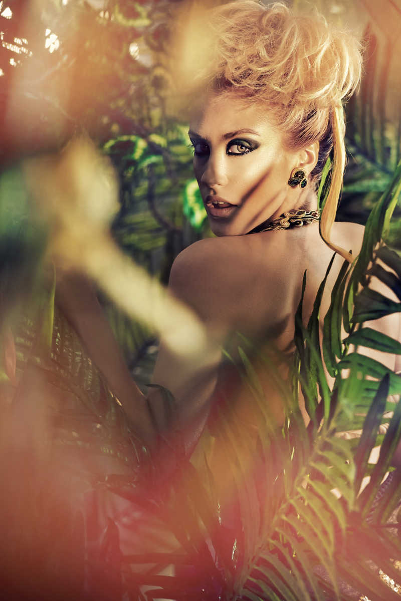 迷人的金发女郎在丛林中摆姿势