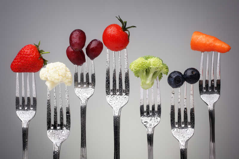 刀叉上带有水滴的新鲜蔬菜和水果