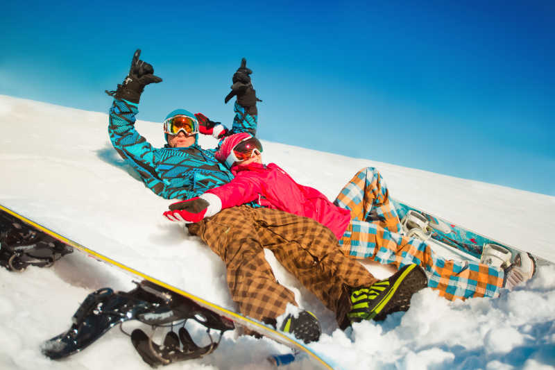 快乐的男女孩躺在雪地里