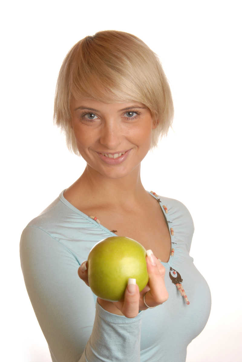 手拿绿色苹果的健身女孩