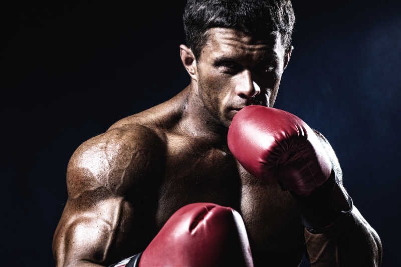 黑色背景上的健壮拳击运动员