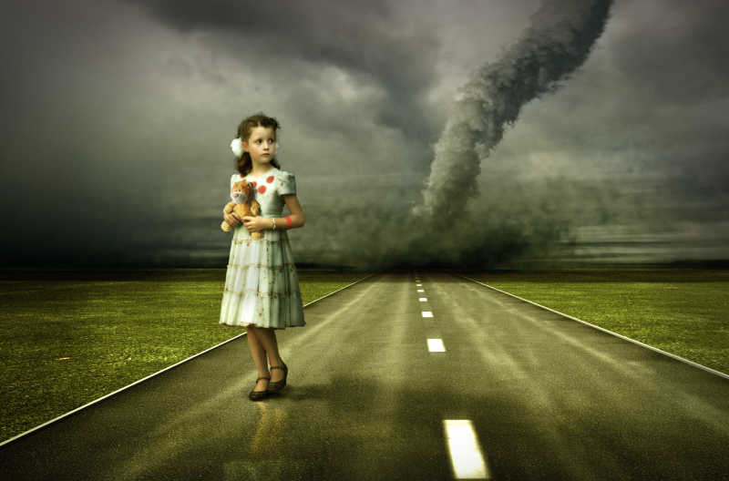 龙卷风背景下站在道路上的女孩