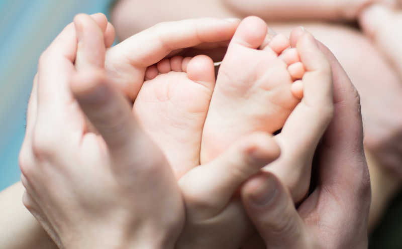 年轻父母共同捧着婴儿脚
