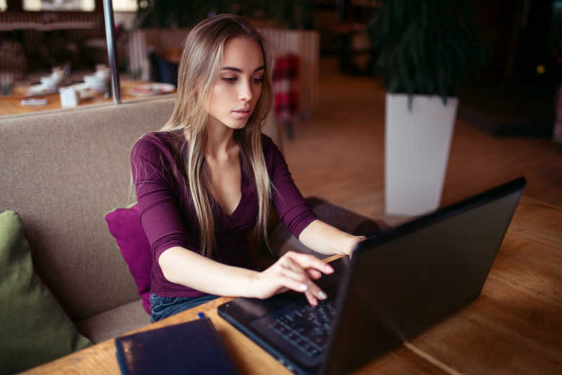坐在咖啡馆里玩电脑的女人