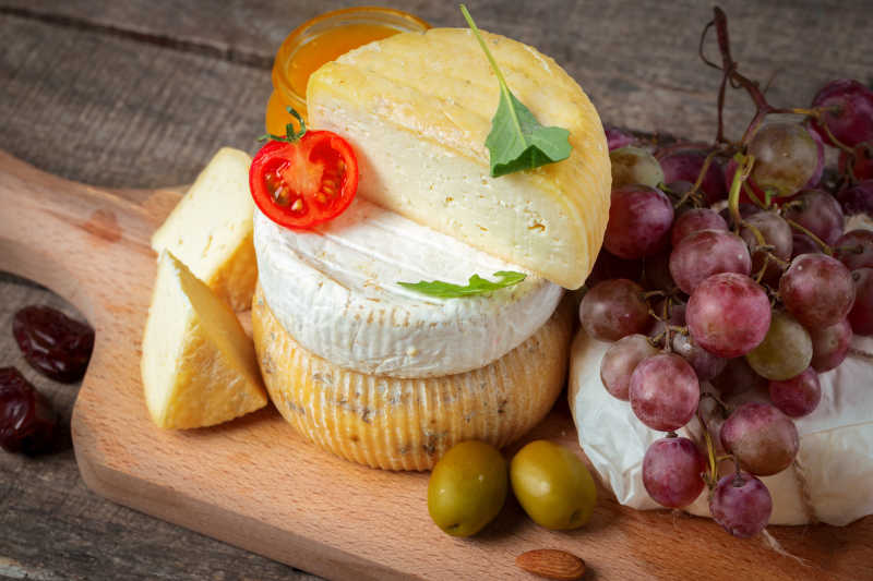 木板上新鲜的奶酪和水果