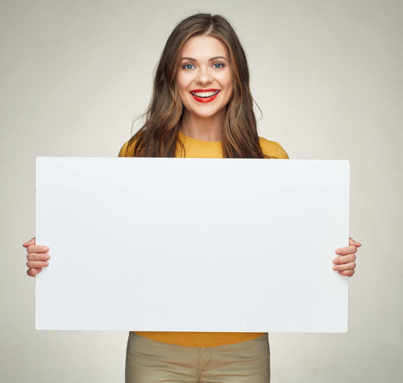 微笑的年轻女子展示白色牌子做广告牌