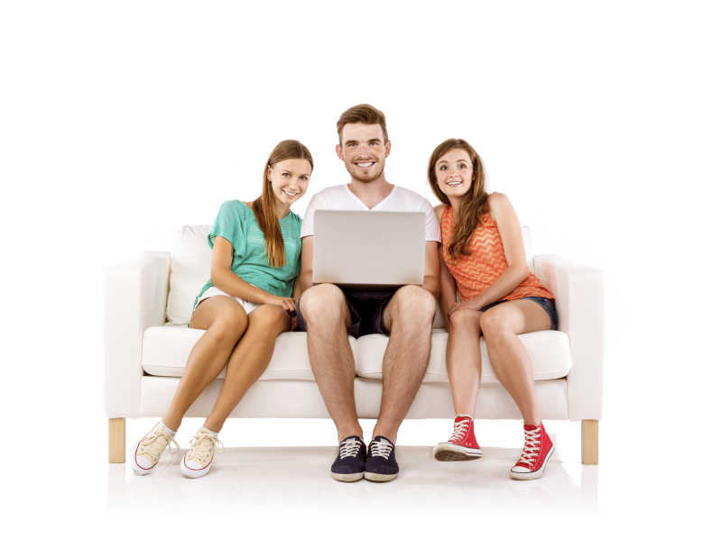 三个年轻人坐在沙发上用笔记本电脑