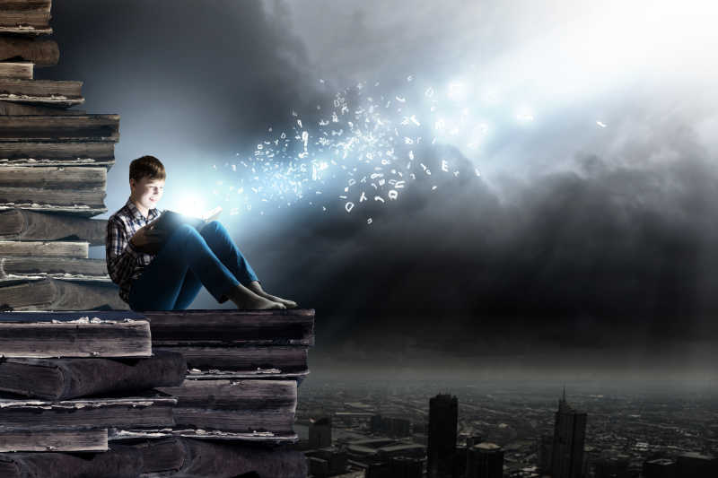 天空下阅读书籍的男孩梦幻背景