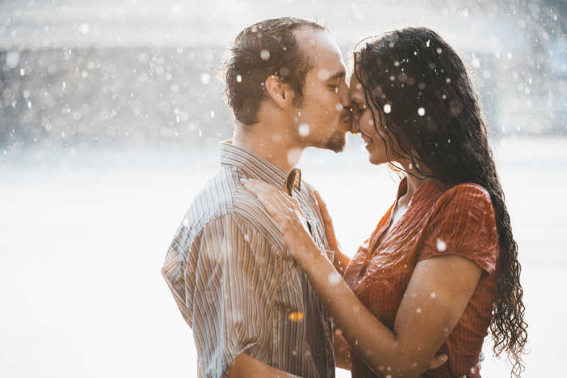 在雨中亲吻女人鼻子的男人