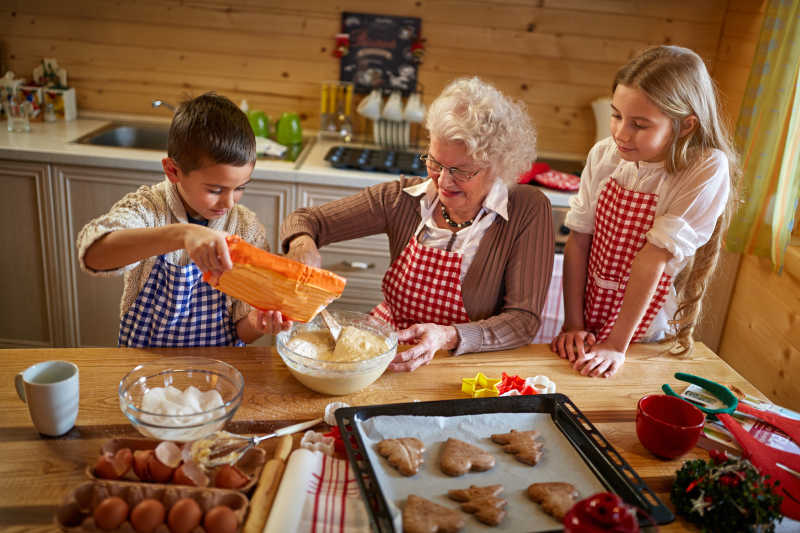 木色厨房内奶奶和孩子们做圣诞节甜点