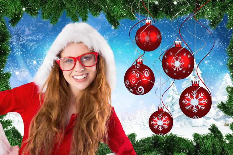 穿着圣诞服带着红色眼镜的的微笑的美人