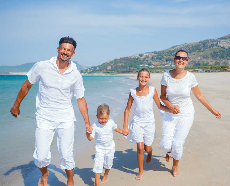在海滩上慢跑的幸福的一家人