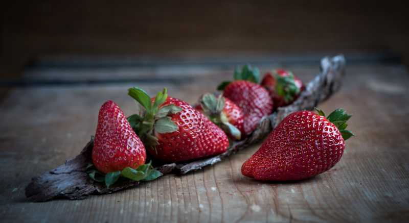 旧木桌上的放置的成熟草莓