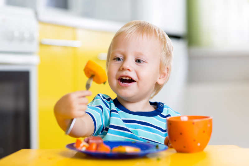 可爱的小男孩在厨房里吃健康食品