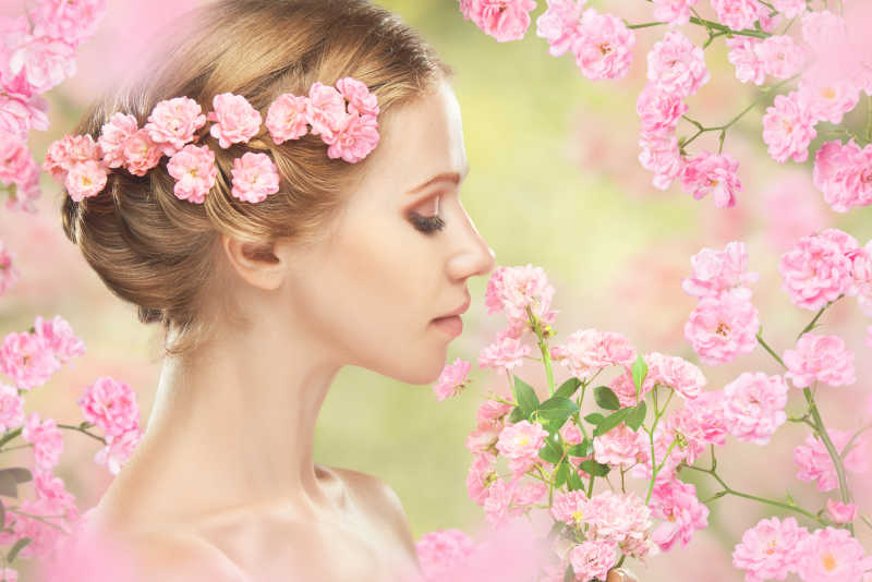 她头发上有粉红色花朵的年轻漂亮女人
