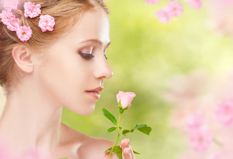 美丽的少女在她的头发上有朵粉红色的花