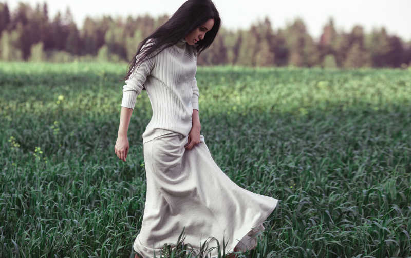 草丛中白色裙子的黑色直发美女