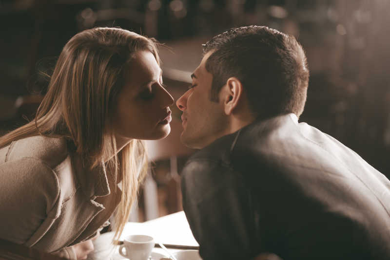 在咖啡馆亲吻的年轻情侣