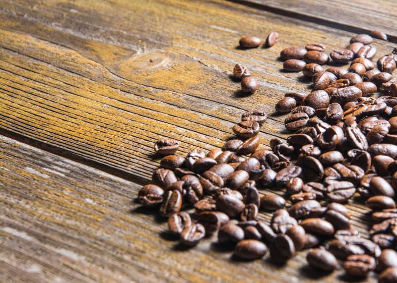 旧木桌上的棕色咖啡豆