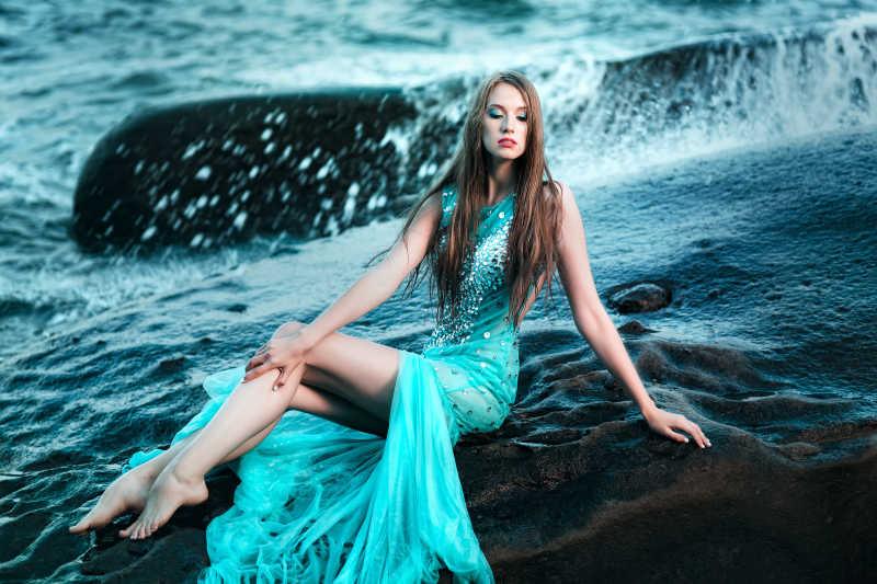 海滩上身穿蓝色长裙的性感美女