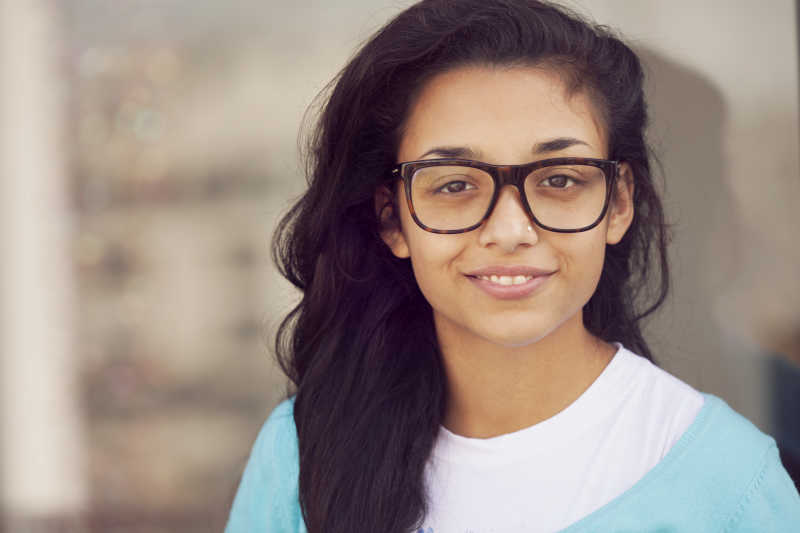 戴眼镜微笑的印度年轻女子