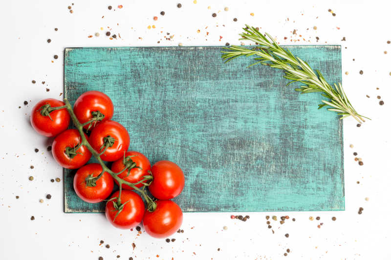 白色背景下的西红柿迷迭香和木板