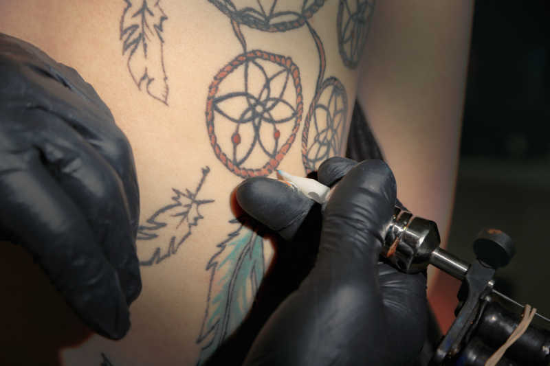 纹身师展示制作纹身的过程中