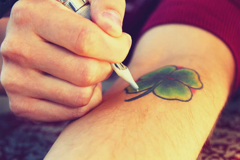 绘制四叶草图案的纹身师