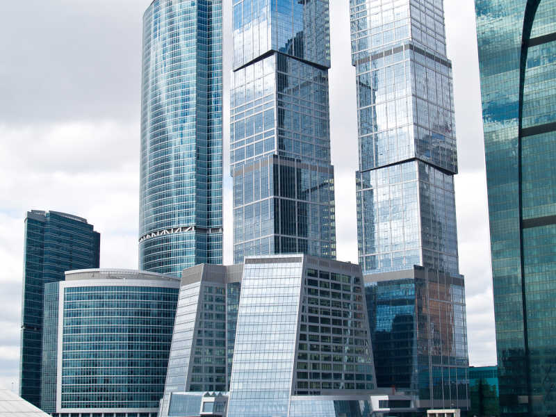 现代钢与玻璃结构的摩天大楼反射天空