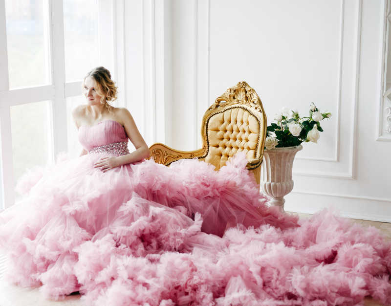 穿着华丽的粉红色连衣裙的美丽孕妇