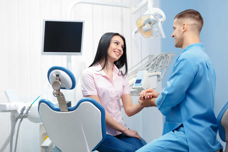 男性牙医与女病人在握手
