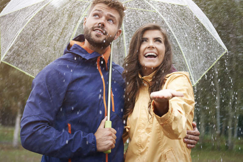 情侣夫妇在雨中撑伞
