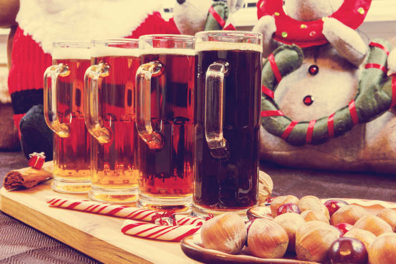 圣诞节木板上的四杯啤酒