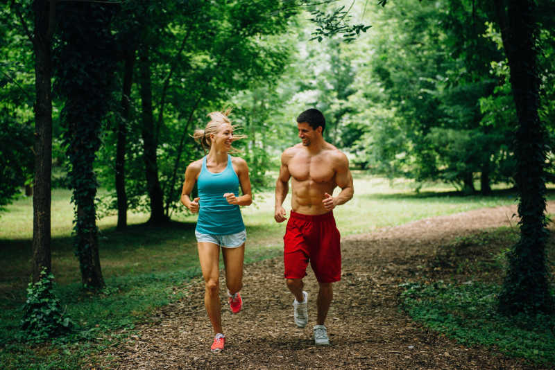 绿茵小路上慢跑的年轻夫妇