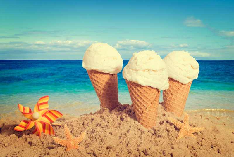 插在海滩上的三支香草味冰淇淋