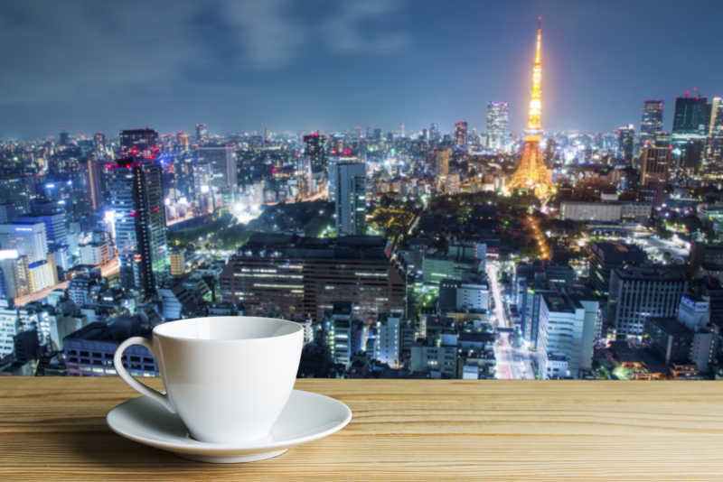 巴黎城市夜景模糊背景下的白色咖啡杯