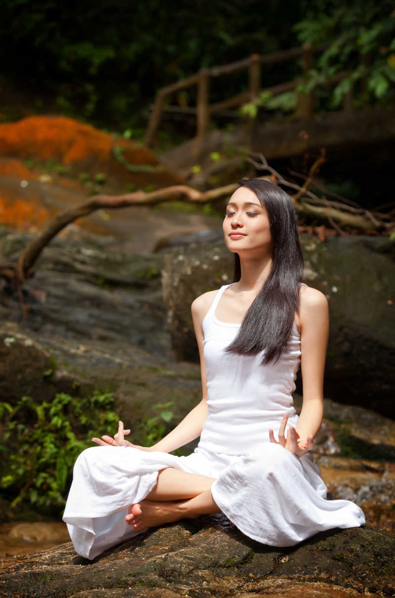 练习瑜伽的亚洲美女在户外自然森林