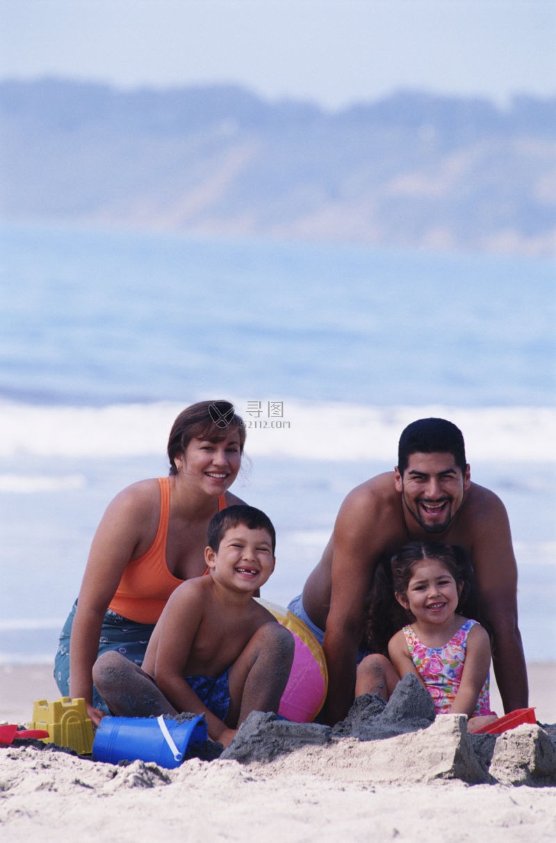 快乐度假的一家人在海滩边