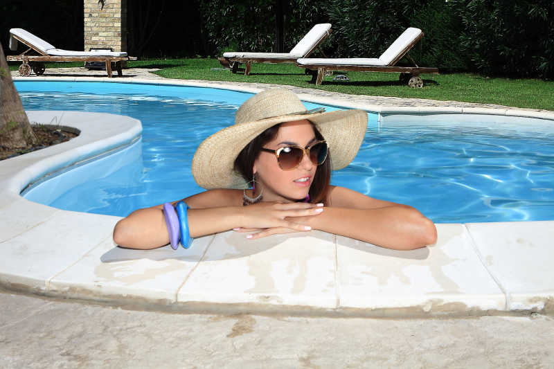 戴着太阳帽眼镜的女人在泳池里