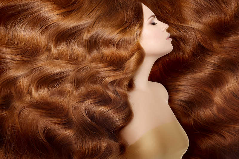 美发沙龙的红色长波浪卷曲发型的时装模特儿