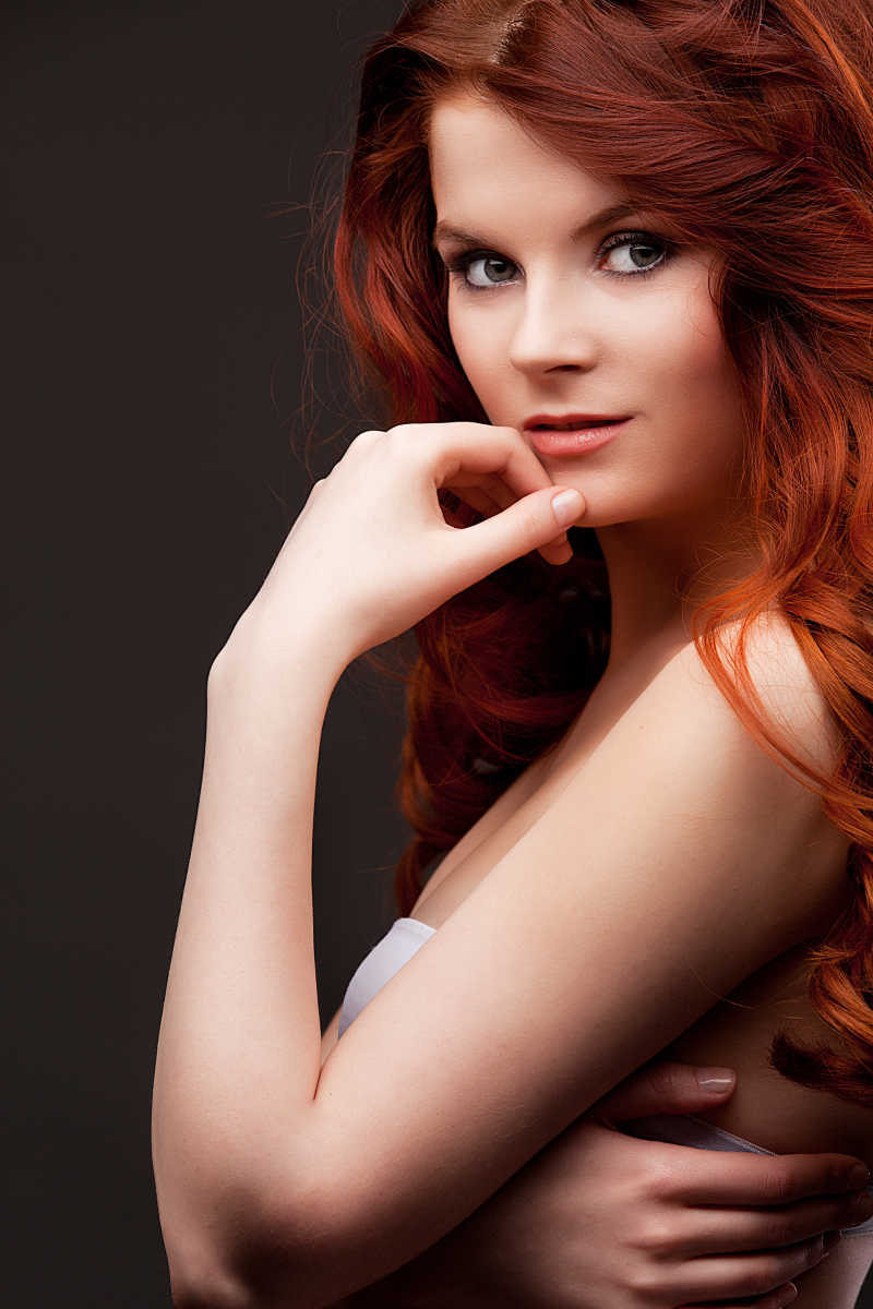 长长的红色发亮的头发的美丽的年轻女人的肖像