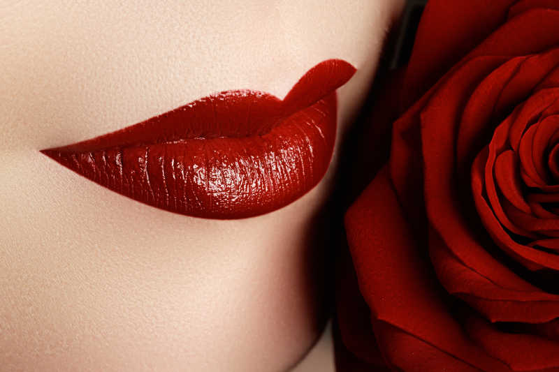 深红色唇膏和美丽的红玫瑰