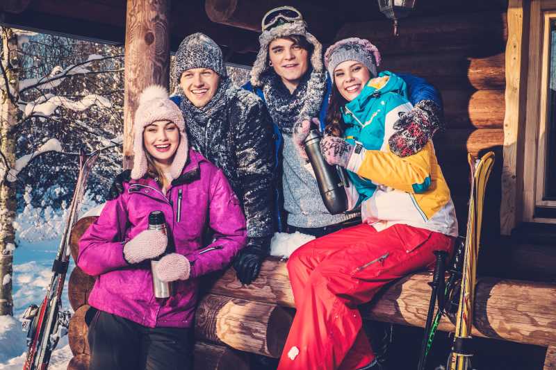 年轻人在雪山里的小木屋度假