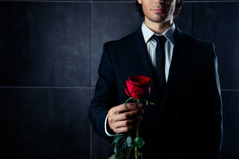 照片中的帅哥手持红玫瑰的特写镜头